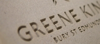 A stone with the Greene King logo etched onto it.