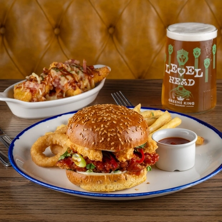Plates of food and a pint of Level Head on a table.