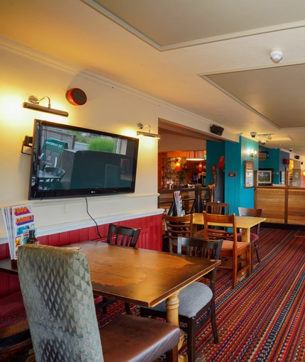 Interior dining area of a pub with a TV.