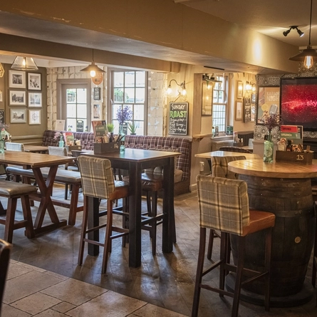 interior dining area of a pub with a fireplace and a TV