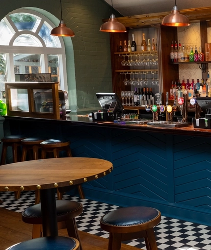 A close up view of the bar inside the Clocktower in Milton Keynes, with tables and bar stools.