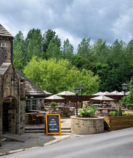 The exterior facade with signage and seating area at the Old Mill.