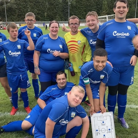 A football team stood posing for the camera.