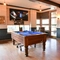 Interior seating area of a pub with a pool table, two gambling machines and a TV.