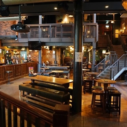 Interior dining area of a pub with a bar and a TV.