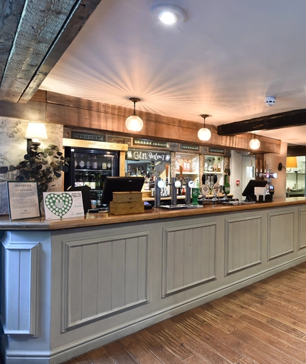 The bar in The Peacock Inn, and some tables nearby.