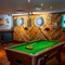 The interior games area at the Counting House in Dumbarton, with a pool table, two illuminated dartboards, and a TV on the wall.