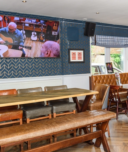 Interior dining area of a pub with a TV.