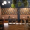 An interior restaurant seating area at The Royal Oak; with long, upholstered booth seats along one wall, and artificial flowers hanging on the walls and ceiling.