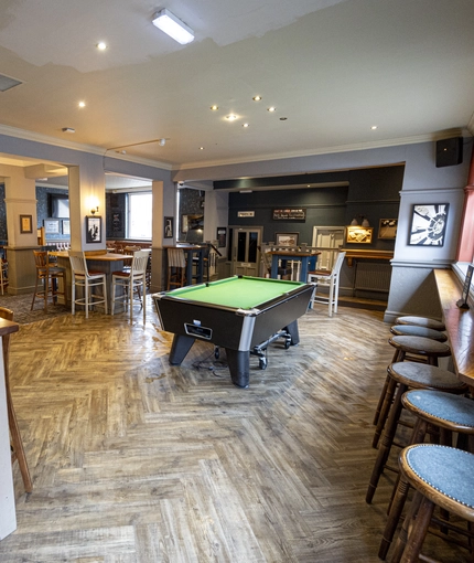 Interior dining area of a pub with a pool table.