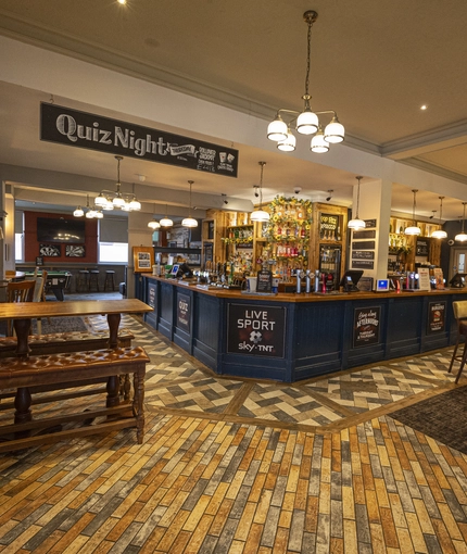 Interior dining area of a pub with a bar.