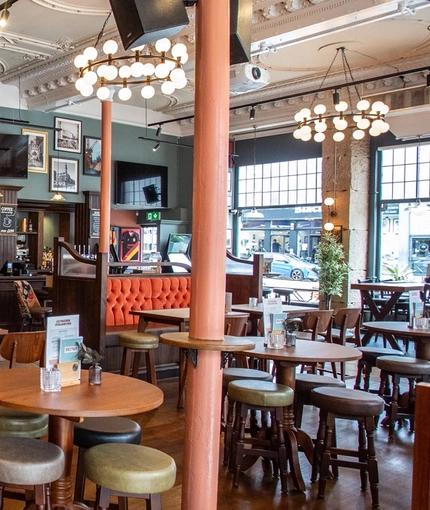 The bar and interior restaurant seating area with TVs, at Coopers in Glasgow.