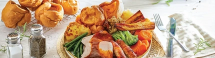 a plate of food sitting on a wooden table of a pub