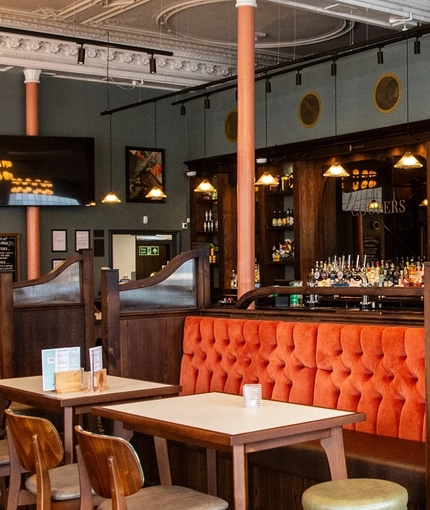 The bar and interior restaurant seating area with TVs, at Coopers in Glasgow.