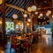 The interior restaurant seating area of The White Hart, with wooden beams, a TV on the wall, and a fireplace.
