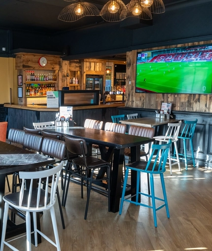 The bar and interior restaurant seating area of Whitehills in Northampton, with TVs on the walls.
