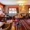 The interior restaurant seating area of The Royal Horse, with wooden tables and upholstered seats.