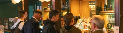 A group of people in the bar area of the Railway Tavern, London.