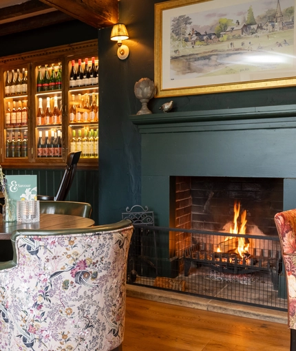 A fireplace next to some restaurant tables at the Grapes.