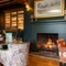 A fireplace next to some restaurant tables at the Grapes.