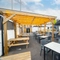 The exterior beer garden seating area at the Counting House in Dumbarton, with wooden picnic tables, padded booth seating, and an under cover area.