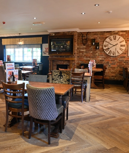 Interior dining area of a pub with a TV and a fireplace.