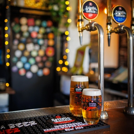 A pint and half a pint of Estrella Galicia sat on the interior bar.