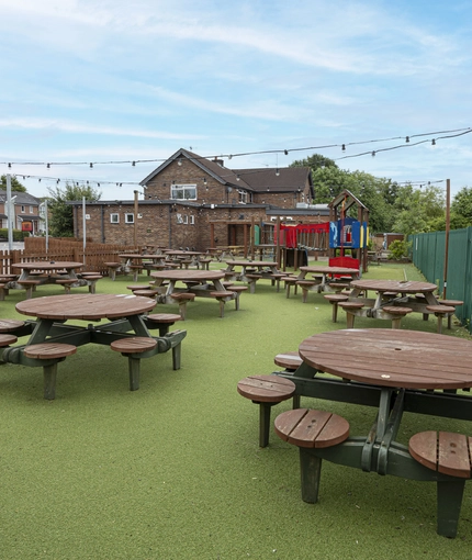 Exterior play area and beer garden of a pub with a seating area.
