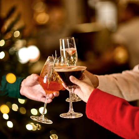 An image of 3 drinks being held during a festive cheers at a Chef & Brewer venue.