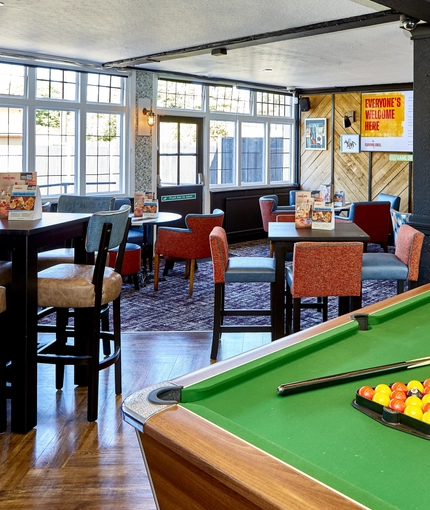 The interior restaurant seating area with TVs and pub games, at The Good Intent in Hornchurch.