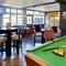 The interior restaurant seating area with TVs and pub games, at The Good Intent in Hornchurch.