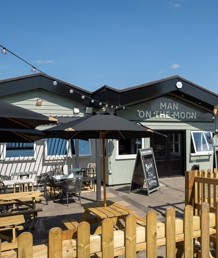 The exterior facade, signage and beer garden seating area of The Man On The Moon in Ipswich.