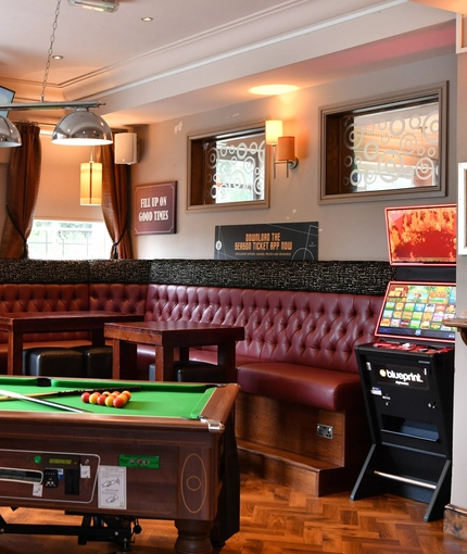 interior dining area of a pub with a pool table and a TV