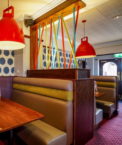 Interior dining area of a pub with a TV.