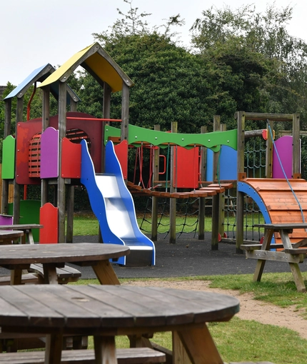 exterior beer garden of a pub with a play area and a seating area