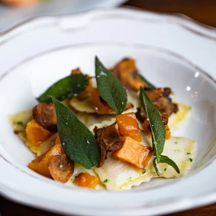 A bowl of vegetable ravioli on a table.