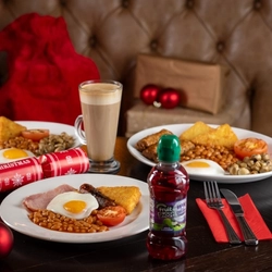 a few plates of food and drinks sitting on a wooden table of a pub
