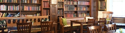 The interior restaurant seating area with tables, chairs, wooden flooring and exposed  wooden ceiling beams at The Plough.