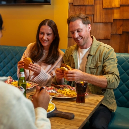 A group of friends enjoying main meals in the restaurant in a Flaming Grill venue.