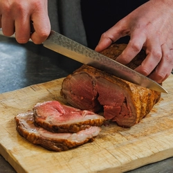 A Chef carving a joint of lamb at the carvery deck at Crafted Venues.