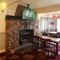 Interior dining area of a pub with a fireplace, a TV and a gambling machine.