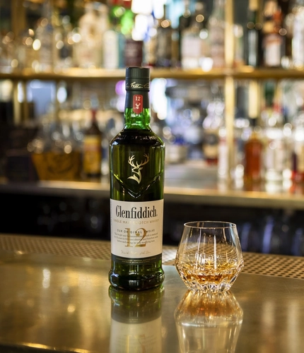 An image showing a bottle and glass of Glenfiddich on a bar,  for the Malt of the Month campaign for Greene King venues.