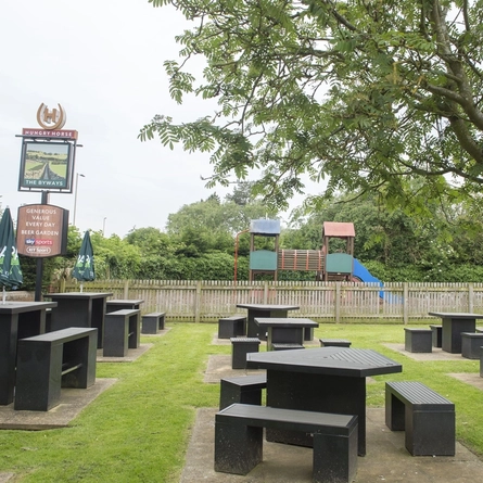 Exterior facade of a pub with a seating area with a play area.