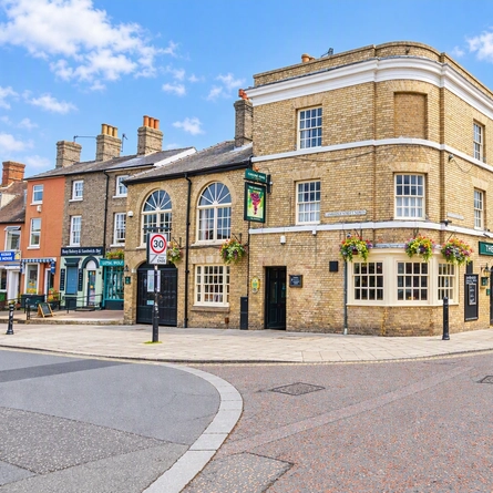 The exterior facade of the venue with hanging venue signage, advertising chalkboards and hanging baskets at The Grapes.