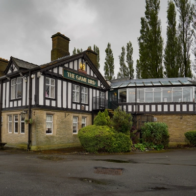 Exterior facade and seating area of a pub.