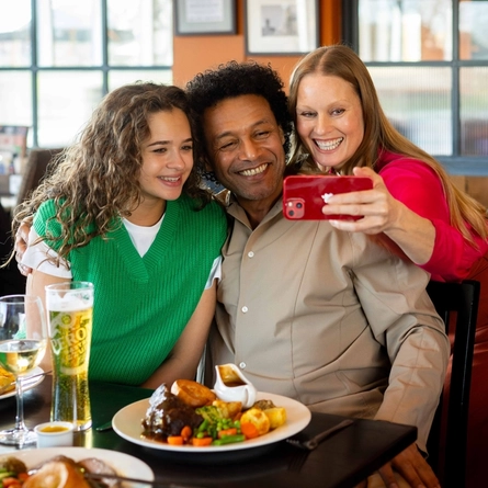 A family enjoying a meal and drinks in the interior restaurant from the new Spring/Summer menu at Flaming Grill.