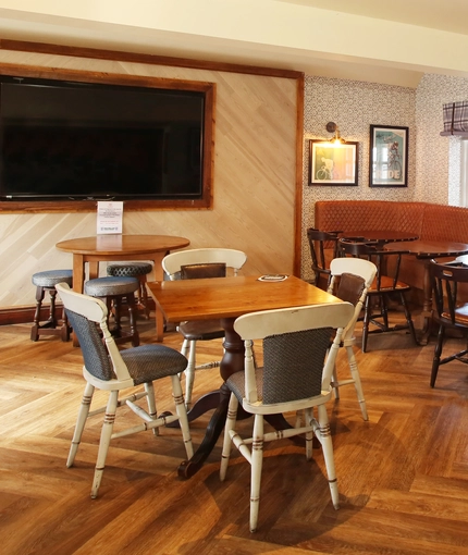 Interior dining area of a pub with a TV.