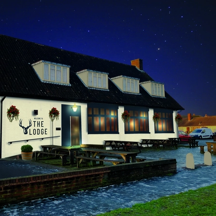 The exterior facade with outdoor seating and car park at The Lodge.