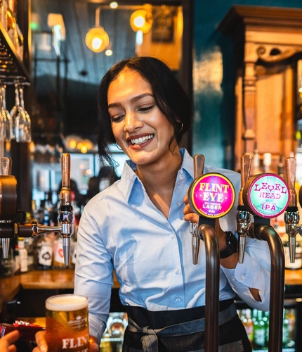 A person serving drinks at the bar