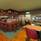 The bar and interior restaurant seating area at The London Apprentice, with bar stool seating, a fireplace, and ornaments on a wooden shelf above the bar.
